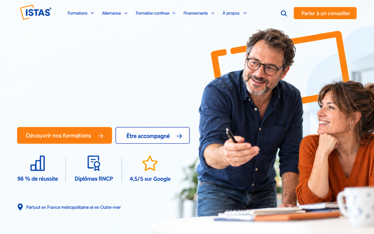 Un formateur échange avec une participante dans un espace de travail lumineux.